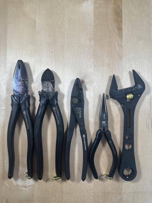 Set of pliers and wrenches on a wooden surface