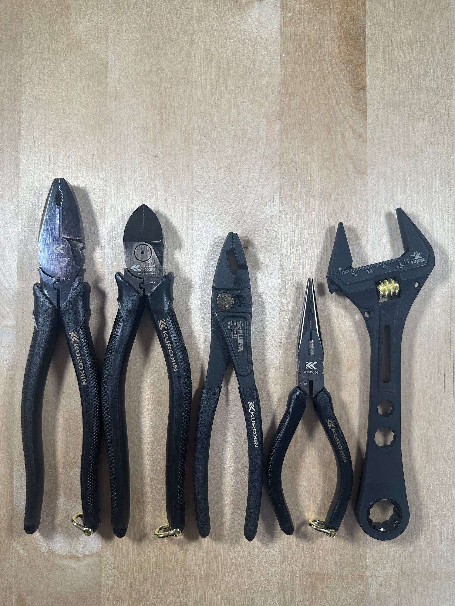 Set of pliers and wrenches on a wooden surface